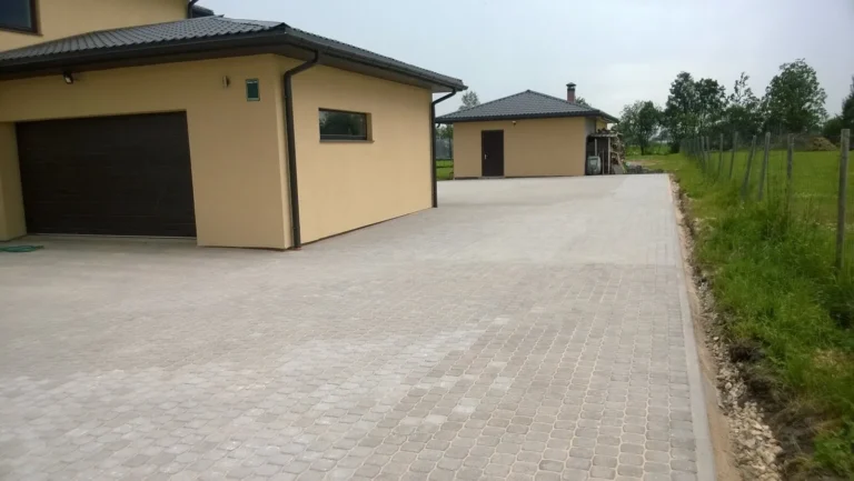 Jauns pelēka bruģakmens segums pie privātmājas garāžas iebrauktuves