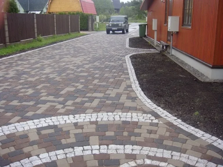 Piebraucamais ceļš pie mājas no daudzkrāsaina bruģakmens ar granīta apmali